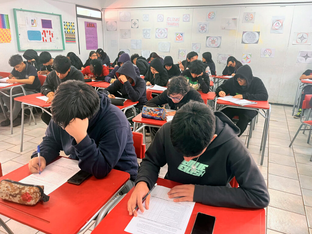 Estudiantes completan una actividad escrita en sala de clases.