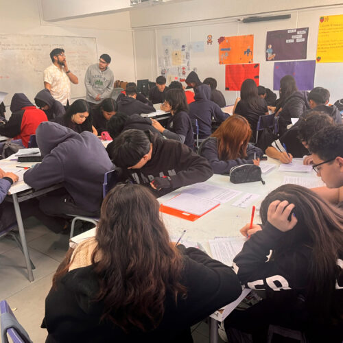 Grupo de estudiantes realizando una actividad en sala de clases.
