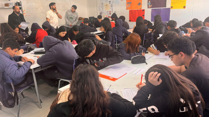 Grupo de estudiantes realizando una actividad en sala de clases.