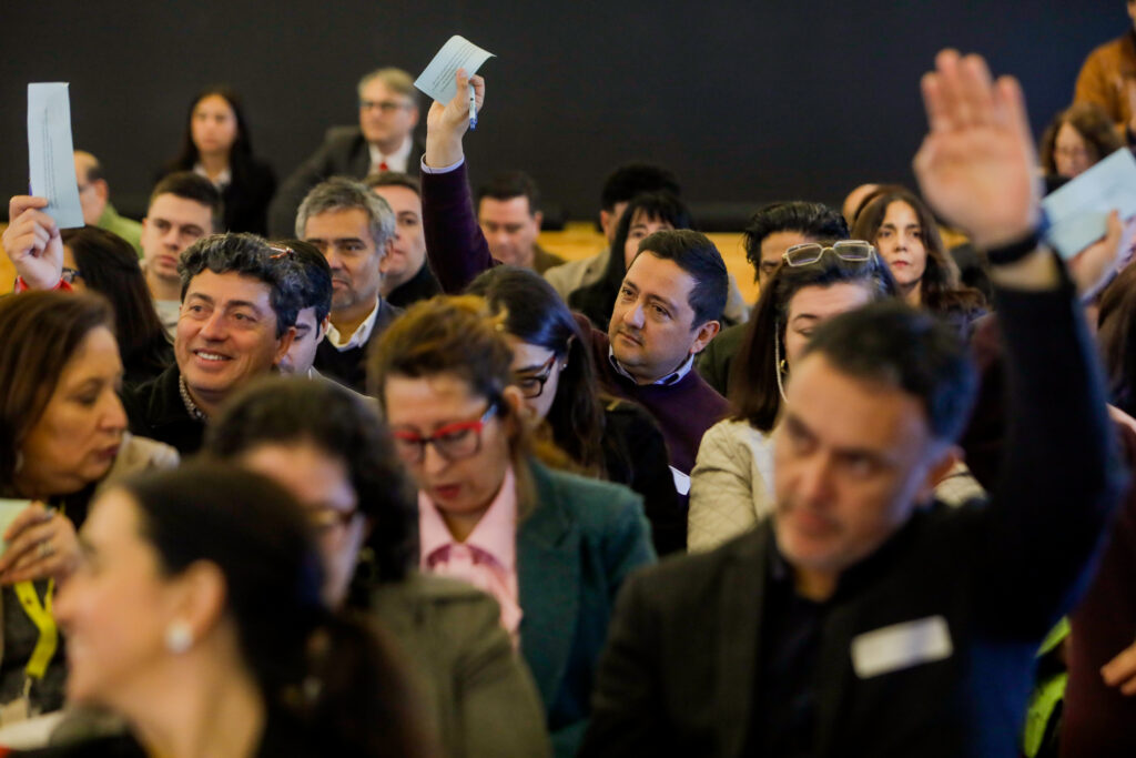Equipos directivos participan levantando sus tarjetas durante una actividad del encuentro.